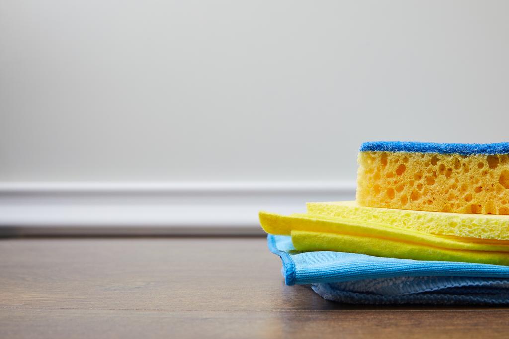 esponja azul e amarela e trapos no chão para limpeza da primavera
 - Foto, Imagem