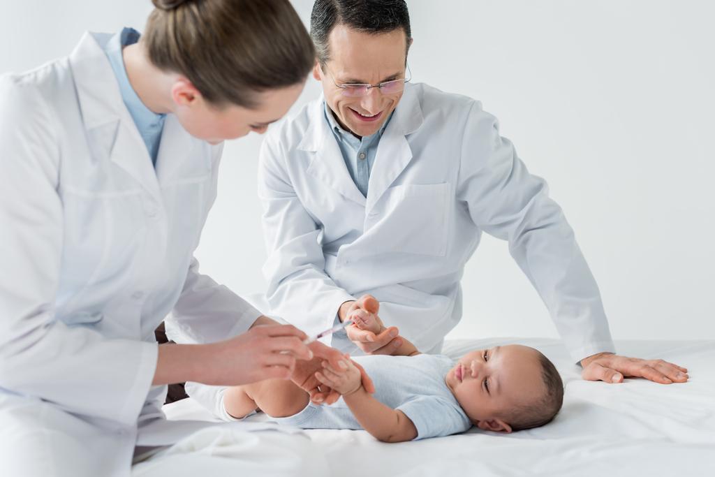 kis baba vakcinázás elvégzésére készül gyermekorvosok - Fotó, kép