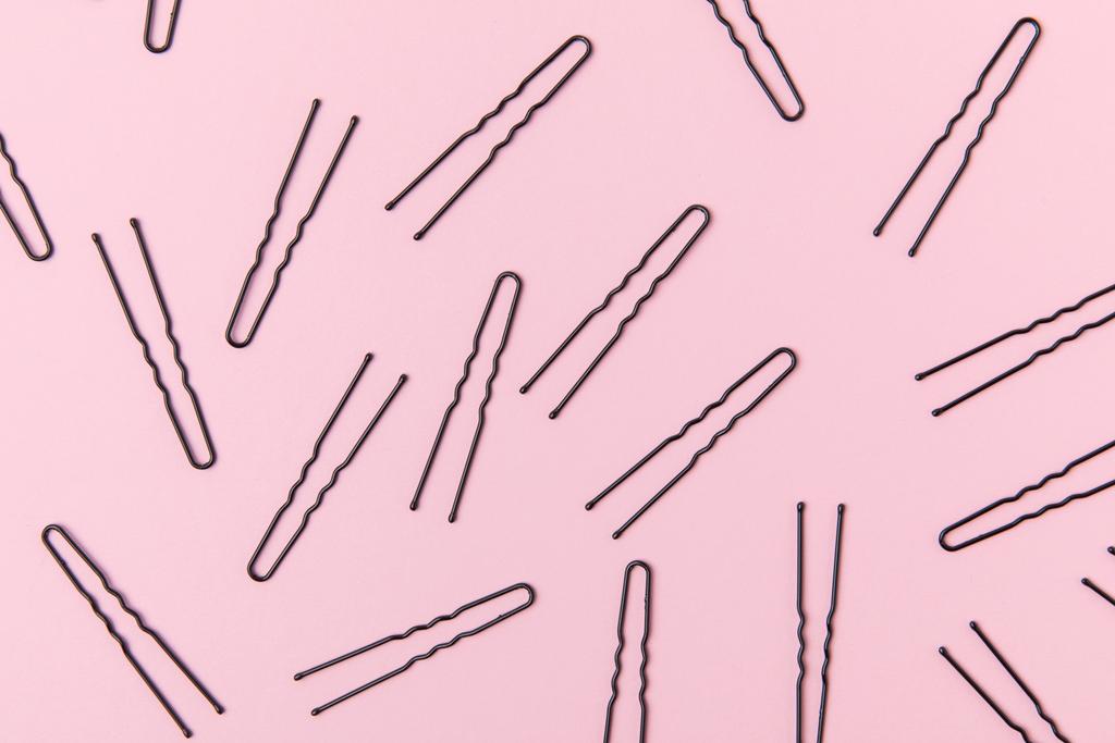 верхний вид черные шпильки, изолированные на светло-розовый
 - Фото, изображение