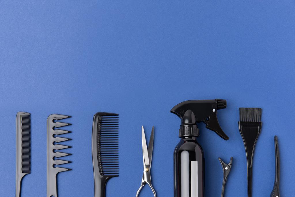tendido plano con herramientas de peluquería negro en fila, aislado en azul
 - Foto, Imagen