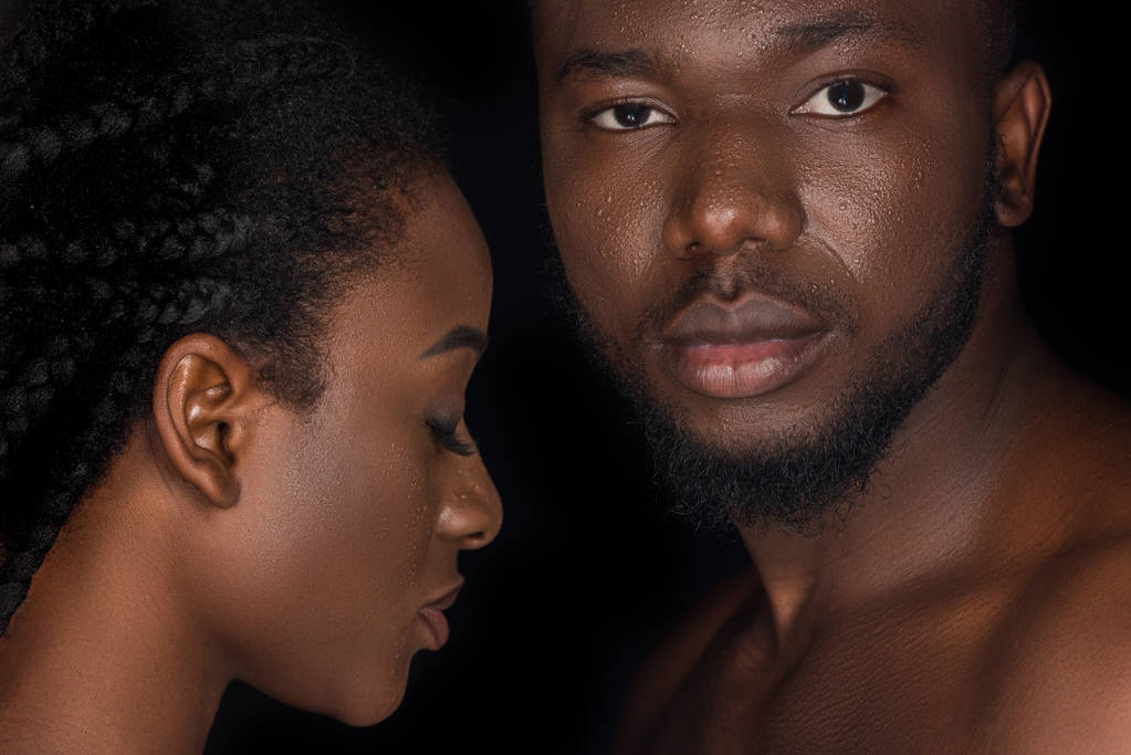 beau jeune couple afro-américain avec des gouttes d'eau sur les visages posant isolé sur noir
  - Photo, image