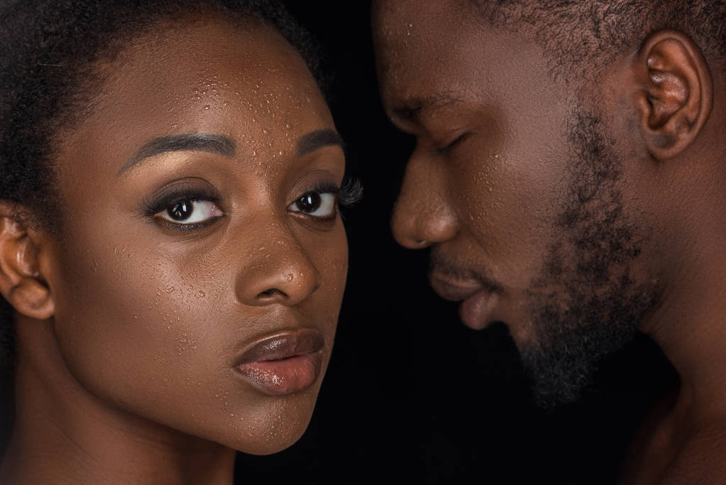 красива афроамериканська пара з краплями води на обличчях позує ізольовано на чорному
  - Фото, зображення