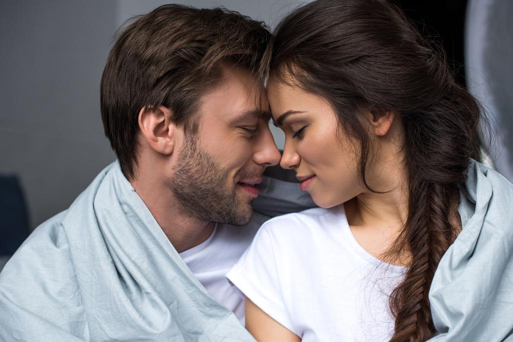 Jeune couple attrayant embrasser sous la couverture
 - Photo, image
