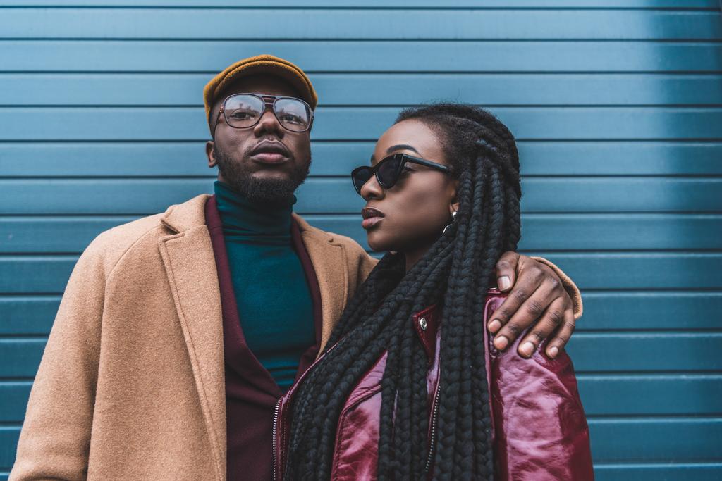 tyylikäs afrikkalainen amerikkalainen pari muodikkaissa vaatteissa poseeraa yhdessä ulkona
 - Valokuva, kuva