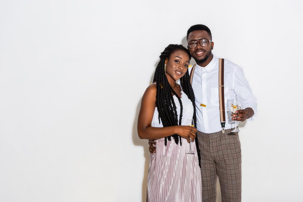 Tyylikäs nuori afrikkalainen amerikkalainen pari syleilee ja pitää lasit viiniä valkoisella
 - Valokuva, kuva