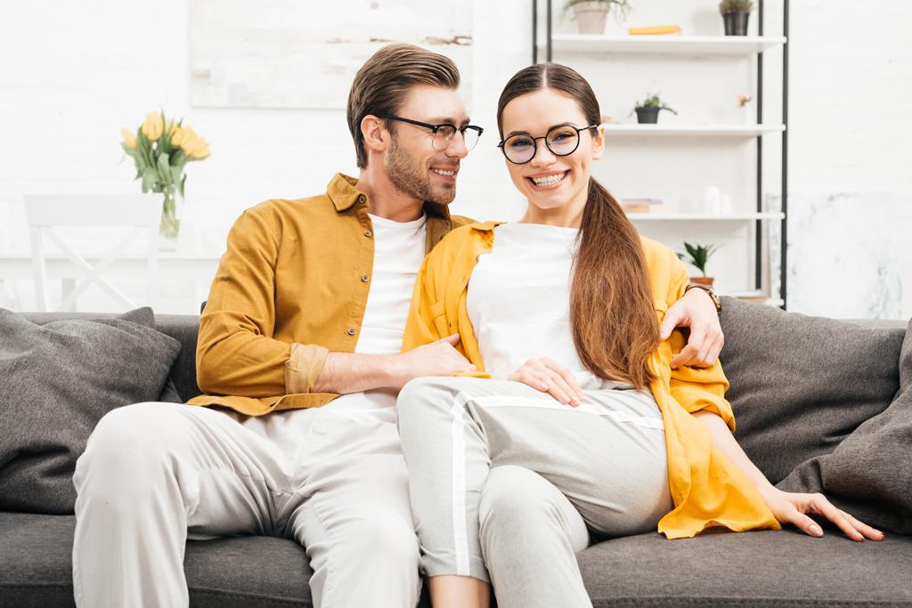 young smiling couple relaxing on comfy couch at home - Photo, Image