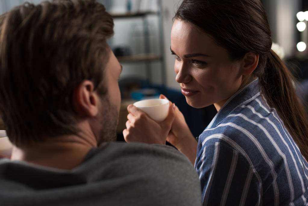 Morena mujer bebiendo café y mirando a su marido
 - Foto, Imagen