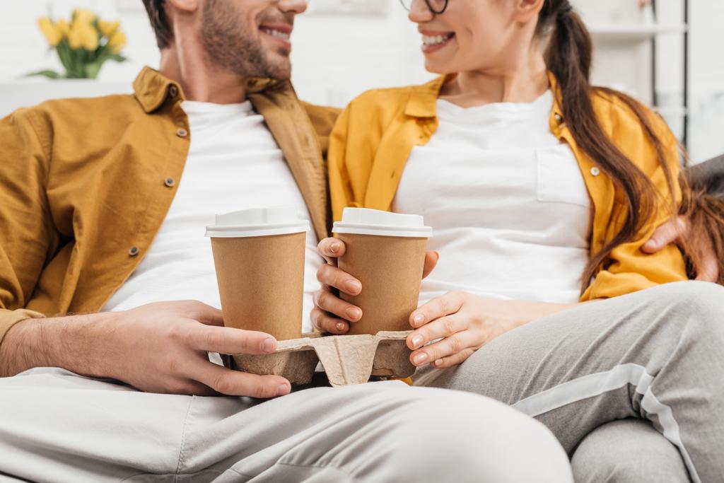 cropped shot of couple drinking coffee from paper cups on couch - Photo, Image