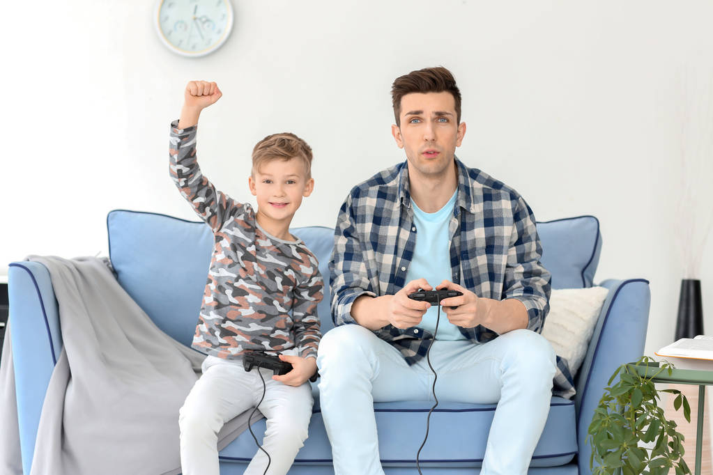 Gelukkig vader en zoon spelen van videospellen thuis - Foto, afbeelding