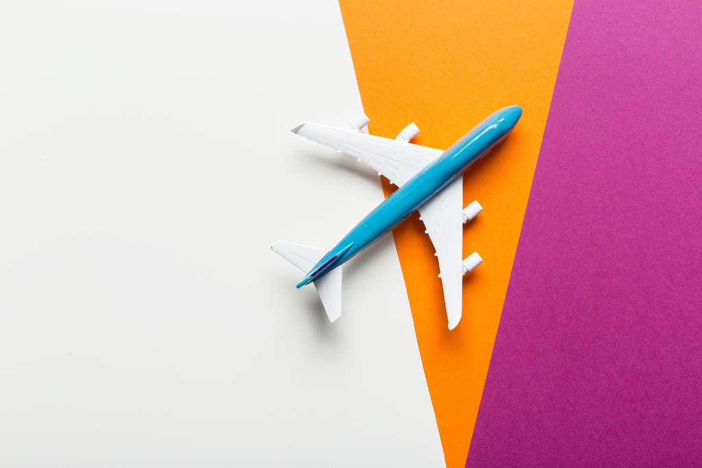 Detailní záběr na miniaturní letadla na barevném pozadí. Cestování nebo dovolenou koncepce - Fotografie, Obrázek
