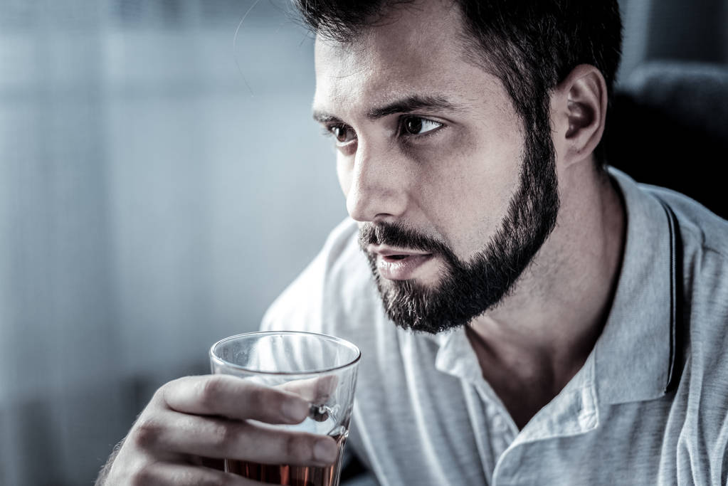 Pensativo hombre concentrado mirando a un lado y bebiendo
. - Foto, Imagen