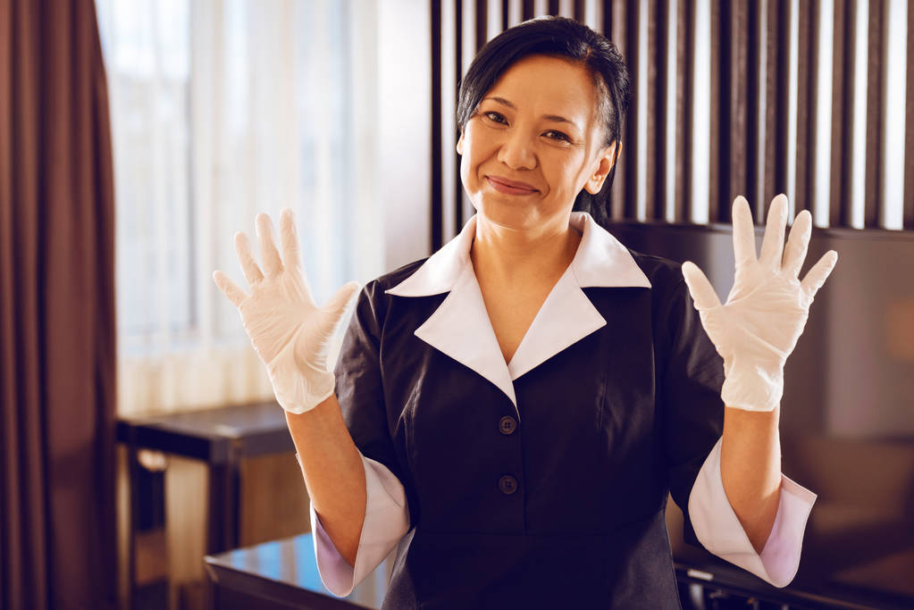 lächelnde Hotelangestellte hebt die Hände - Foto, Bild