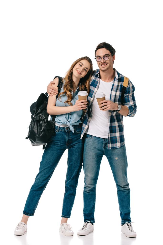 junge Studenten umarmen und halten Einweg-Kaffeetassen isoliert auf weiß - Foto, Bild