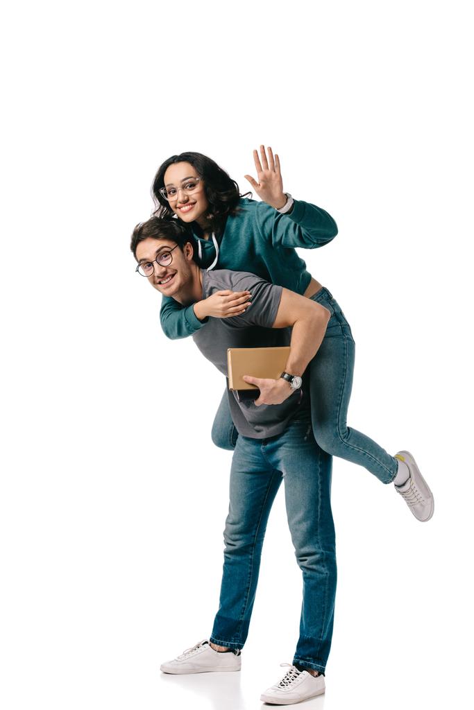 caucasian boyfriend giving piggyback to african american girlfriend and she waving hand isolated on white - Photo, Image