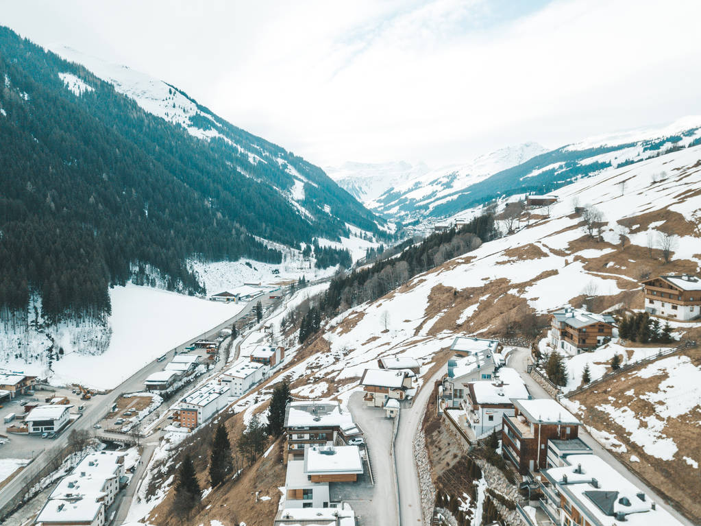 Αεροφωτογραφία του σκι θέρετρο χειμερινών πόλη ή στο χωριό των Άλπεων με μικρά σπιτάκια, εξωτερική πισίνα σκι λιφτ και πίστες - Φωτογραφία, εικόνα
