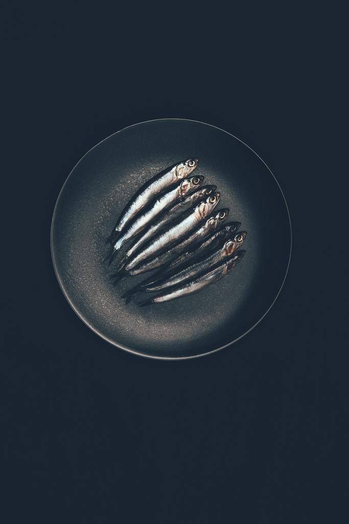 Top view of pile of fish in frying pan isolated on black - Photo, Image
