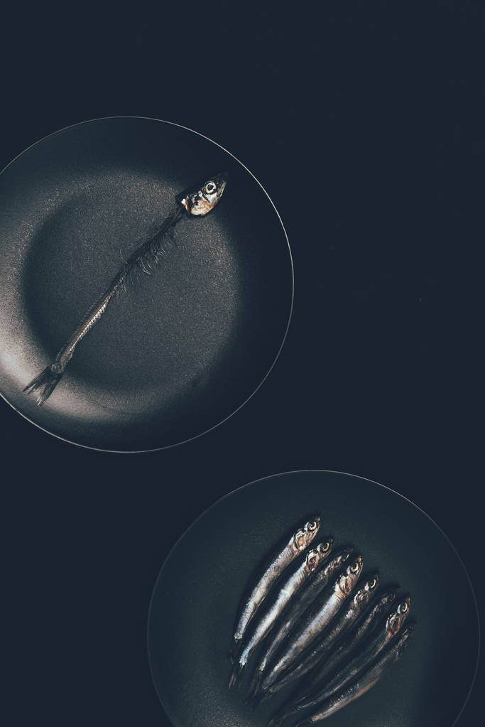 Due padelle con pesce isolato su nero
 - Foto, immagini