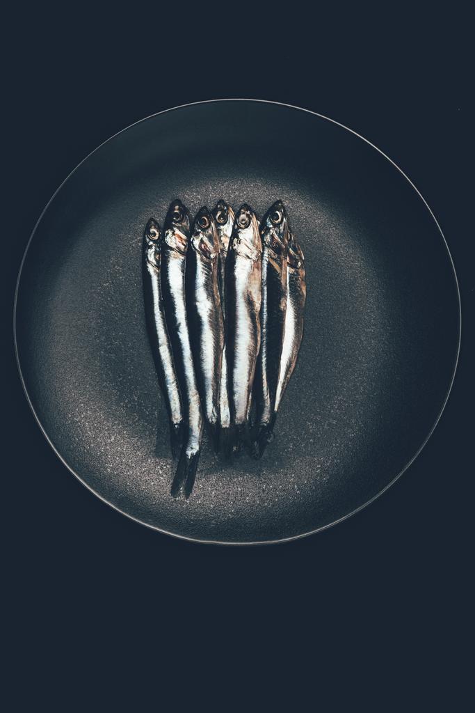 Вид сверху кучи рыбы в сковороде, изолированной на черном
 - Фото, изображение