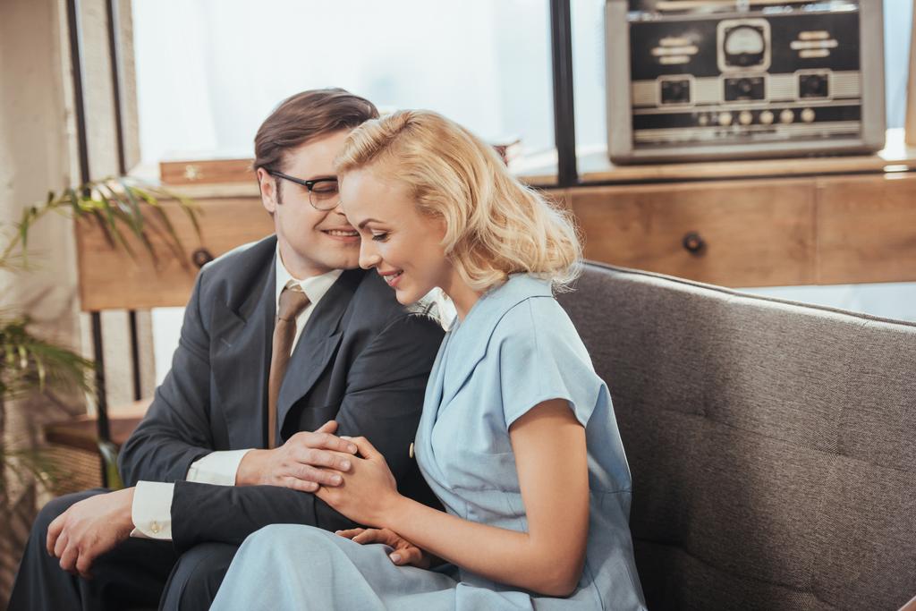 красива щаслива пара сидить на дивані і тримає руки, стиль 1950-х років
 - Фото, зображення
