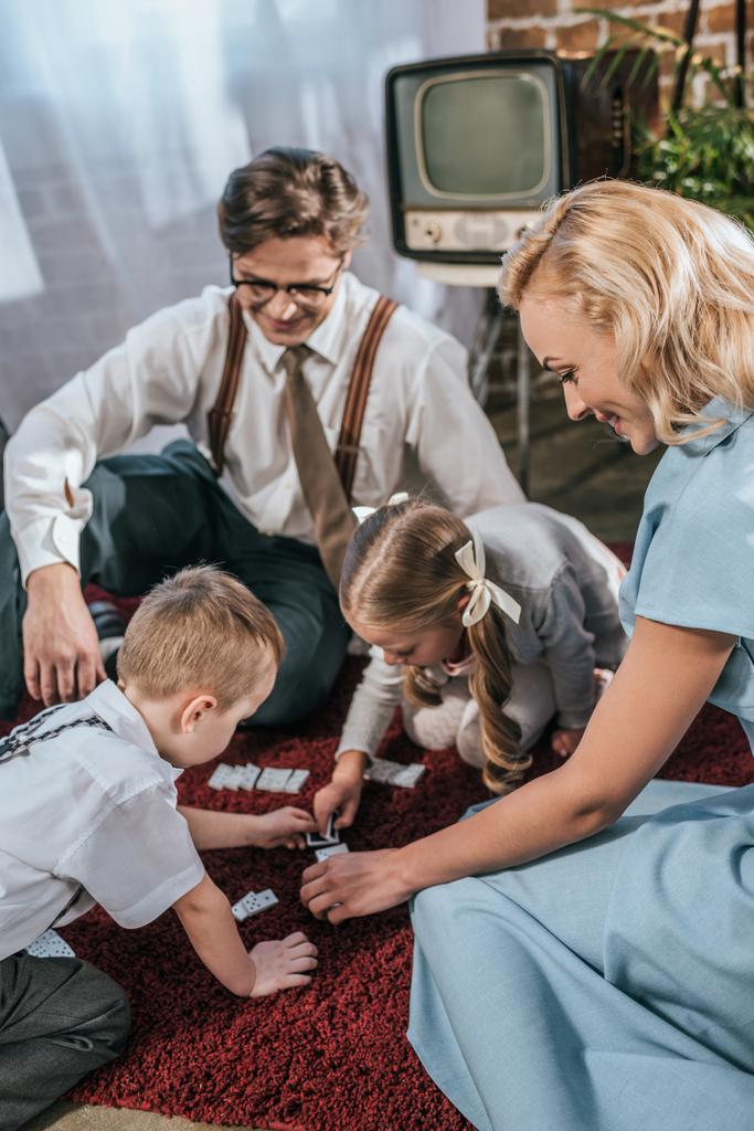 happy family with two kids playing dominoes together at home, 1950s style - Photo, Image