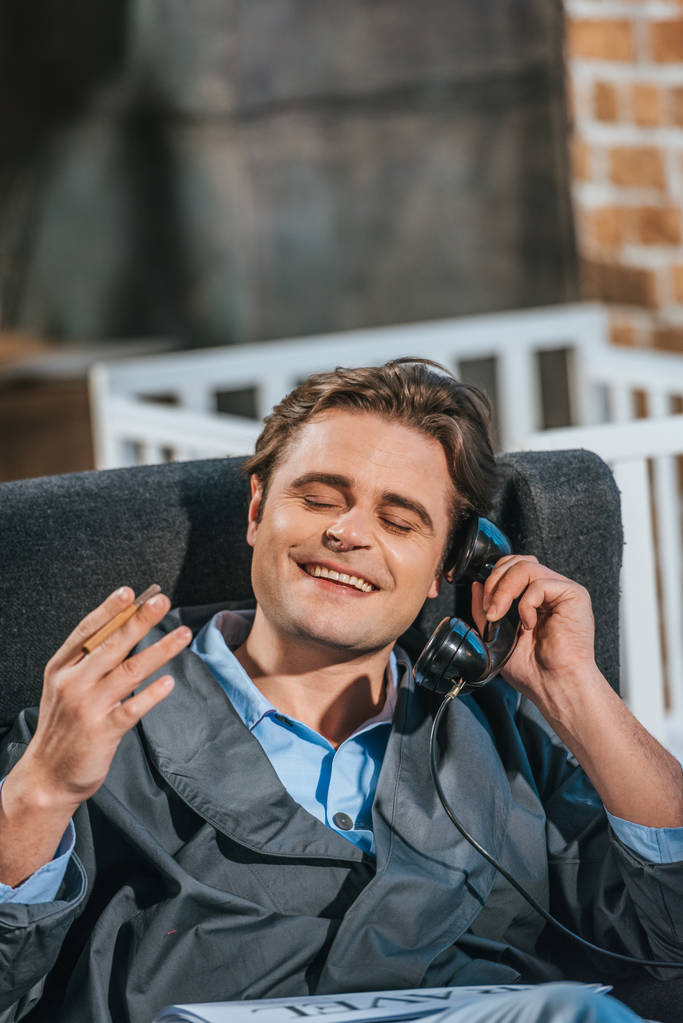 щасливий чоловік в халаті курить сигарету і розмовляє вінтажним телефоном
 - Фото, зображення