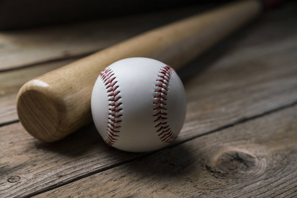 бейсбол і бейсбольна бита на дерев'яному фоні столу, крупним планом
 - Фото, зображення