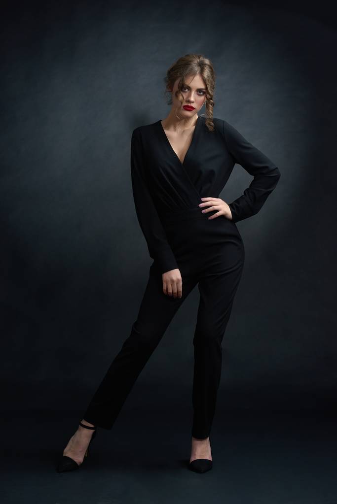 Visão frontal do estúdio de mulher confiante vestindo terno preto
. - Foto, Imagem