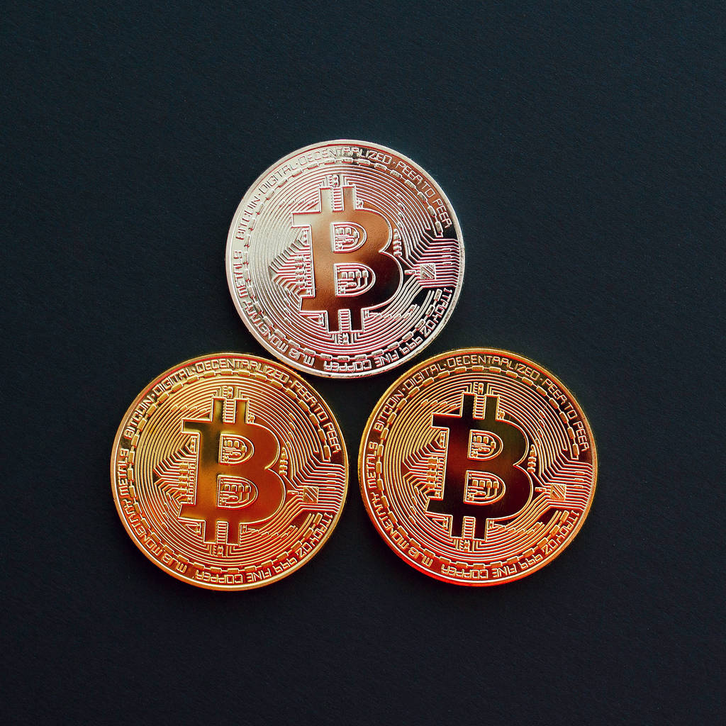 Imagem de três bitcoin ouro sobre fundo preto. Mon digital
 - Foto, Imagem