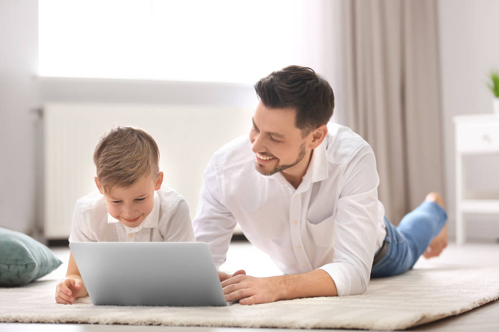 kleiner Junge und sein Vater mit Laptop zu Hause - Foto, Bild