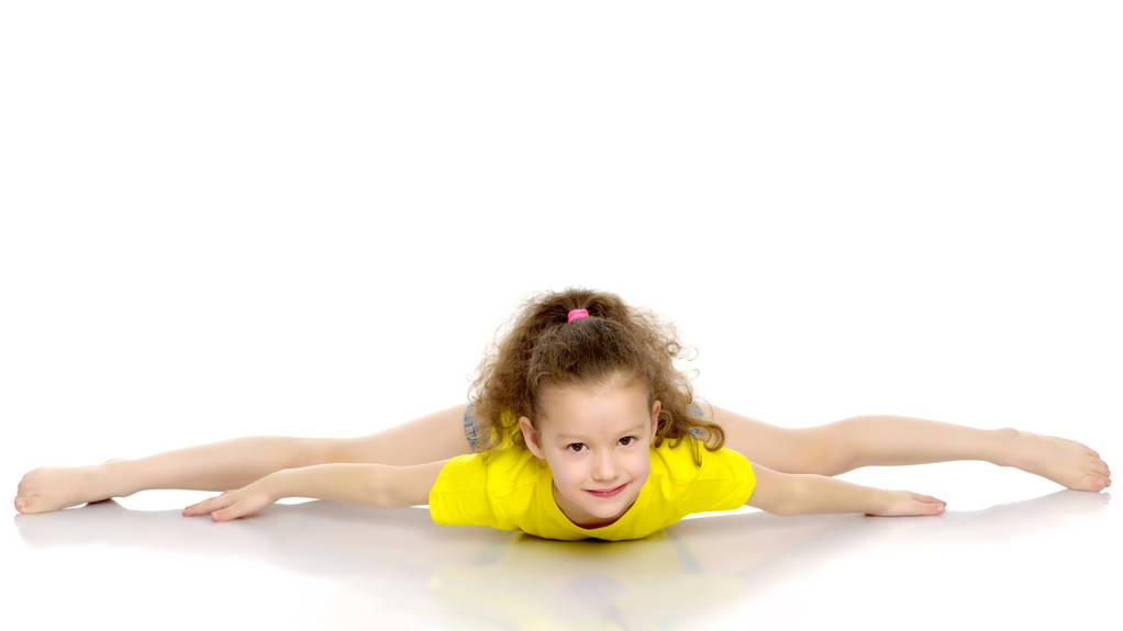 Malý gymnastka provést akrobatický prvek na podlaze. - Fotografie, Obrázek