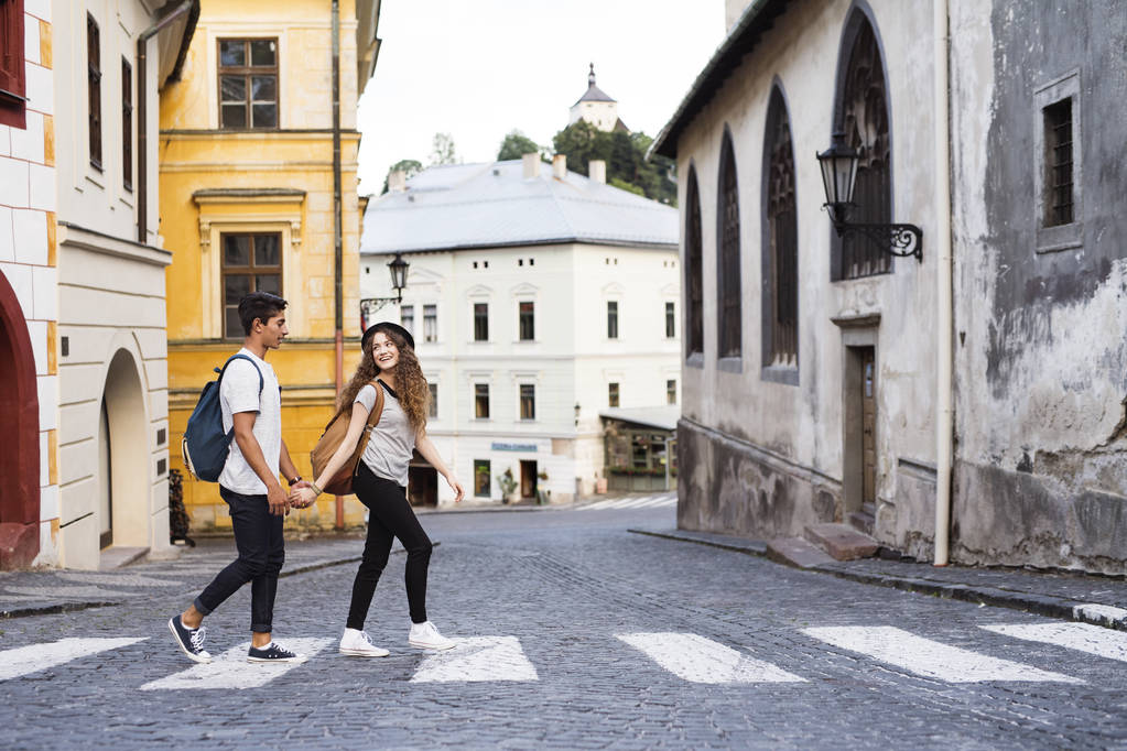 Двоє молодих туристів перетинають дорогу в старому місті
. - Фото, зображення