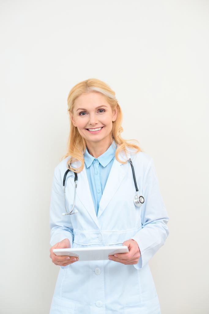 kypsä naislääkäri digitaalisella tabletilla valkoisella
 - Valokuva, kuva