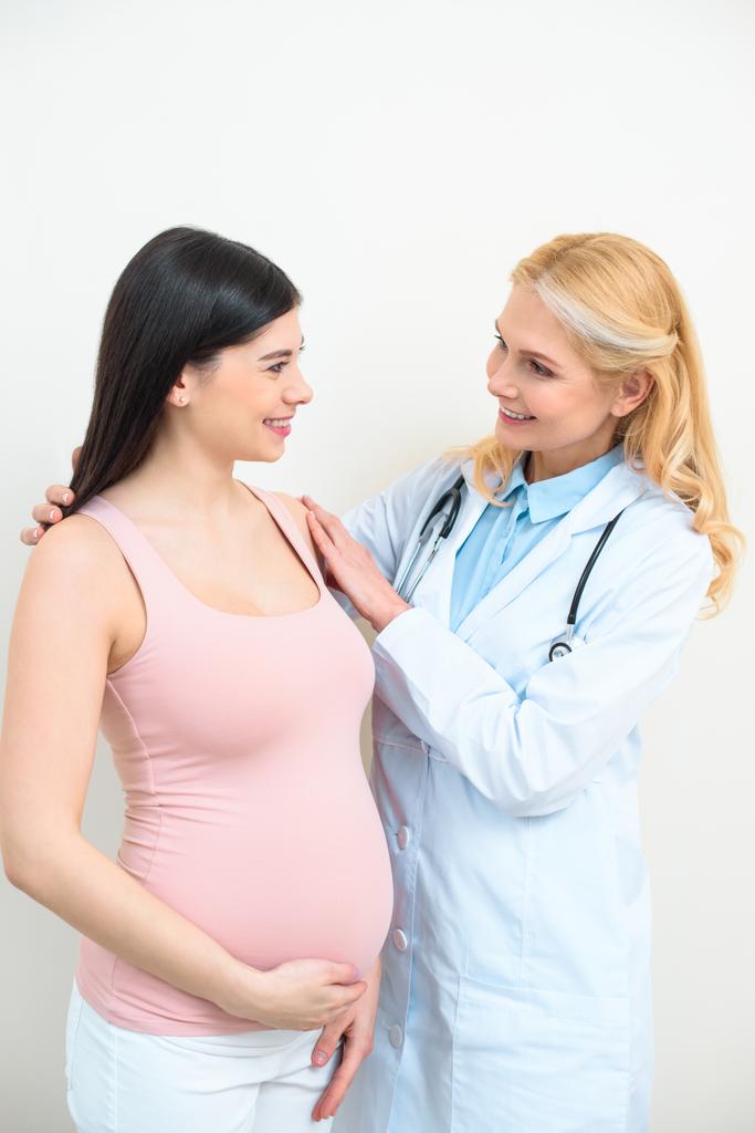 happy mature obstetrician gynecologist supporting pregnant woman - Photo, Image