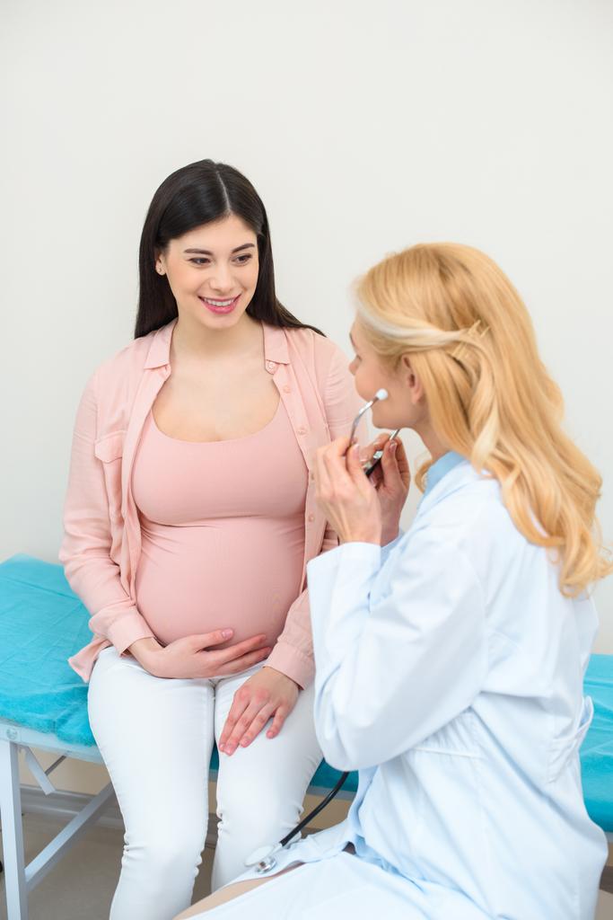 聴診器とクリニックで妊娠中の女性の産科医婦人科医 - 写真・画像