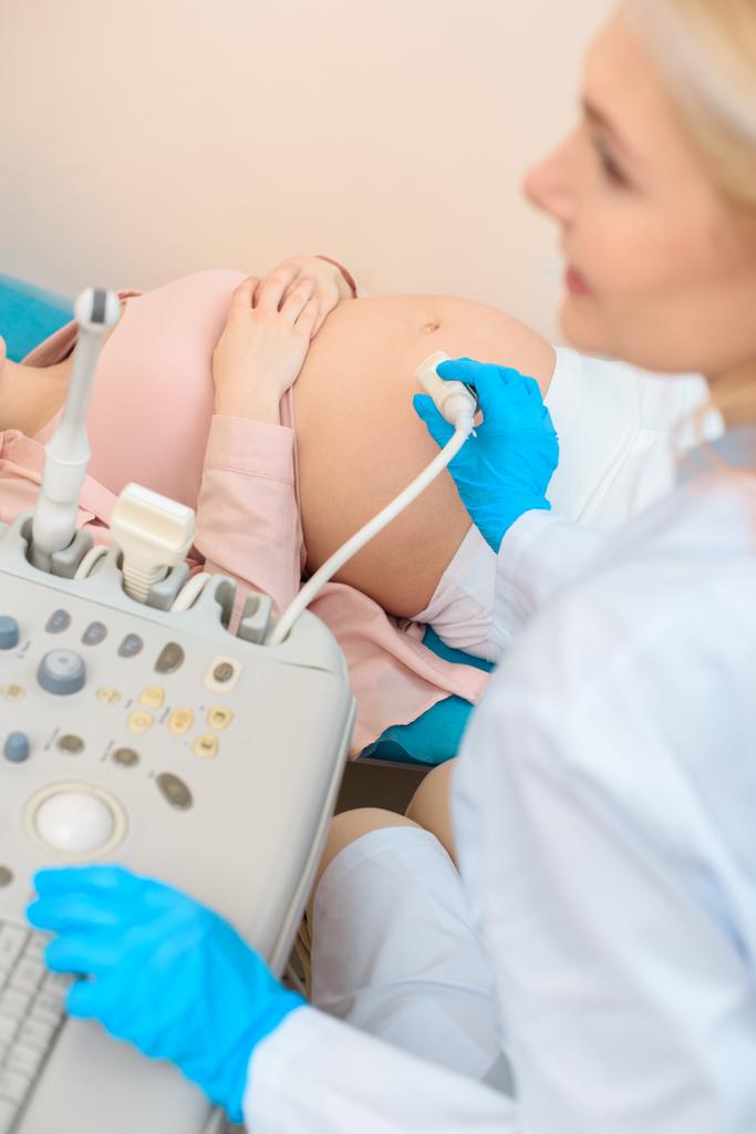 kypsä synnytyslääkäri gynekologi tekee ultraäänitutkimus raskaana olevalle naiselle
 - Valokuva, kuva