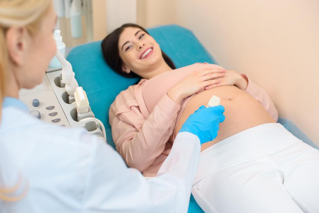 акушер-гинеколог проводит ультразвуковое обследование молодой беременной женщины
 - Фото, изображение