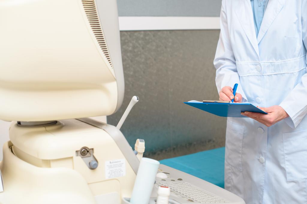 ginecólogo obstétrico frente a escáner ultrasónico escrito en portapapeles
 - Foto, imagen