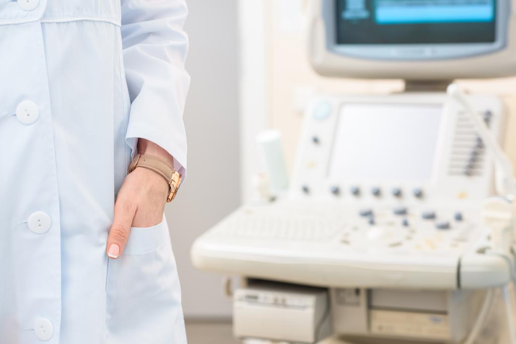 tiro recortado de ginecólogo obstetra en capa con escáner ultrasónico en el fondo
 - Foto, Imagen