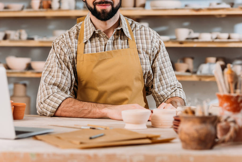 cropped view of man in apron in pottery workshop - Photo, Image