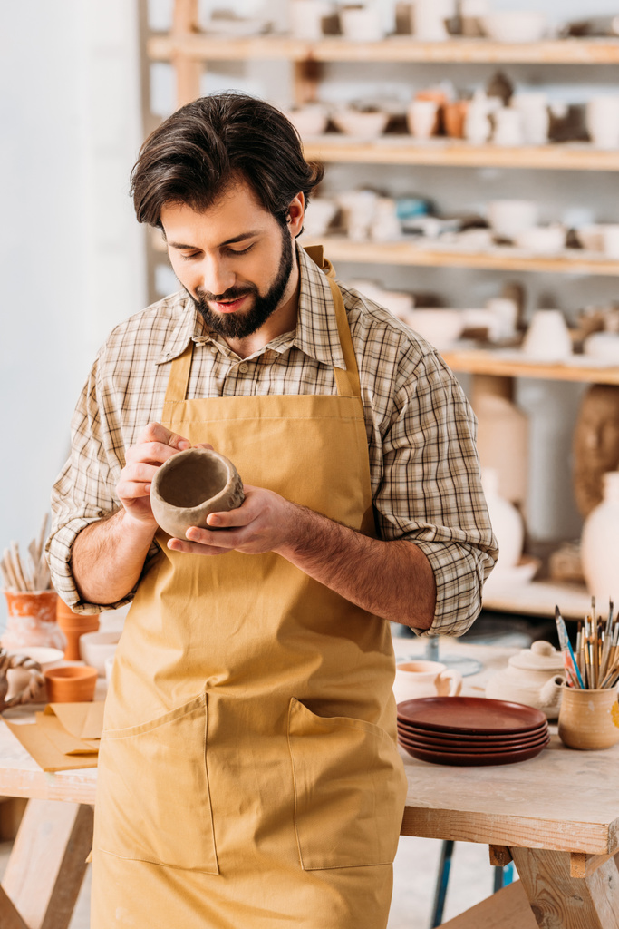 hombre adulto haciendo tazón de cerámica en taller de cerámica
 - Foto, Imagen