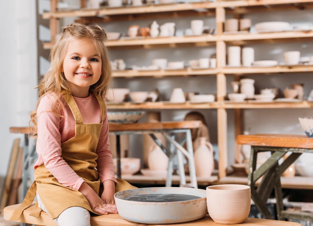 rubia sonriente niño en la clase de cerámica
 - Foto, Imagen