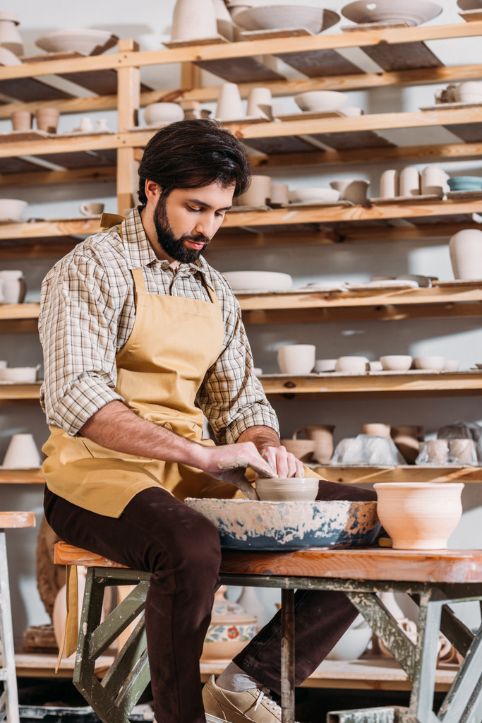pottenbakker maken van keramische pot op aardewerk wiel in werkplaats - Foto, afbeelding