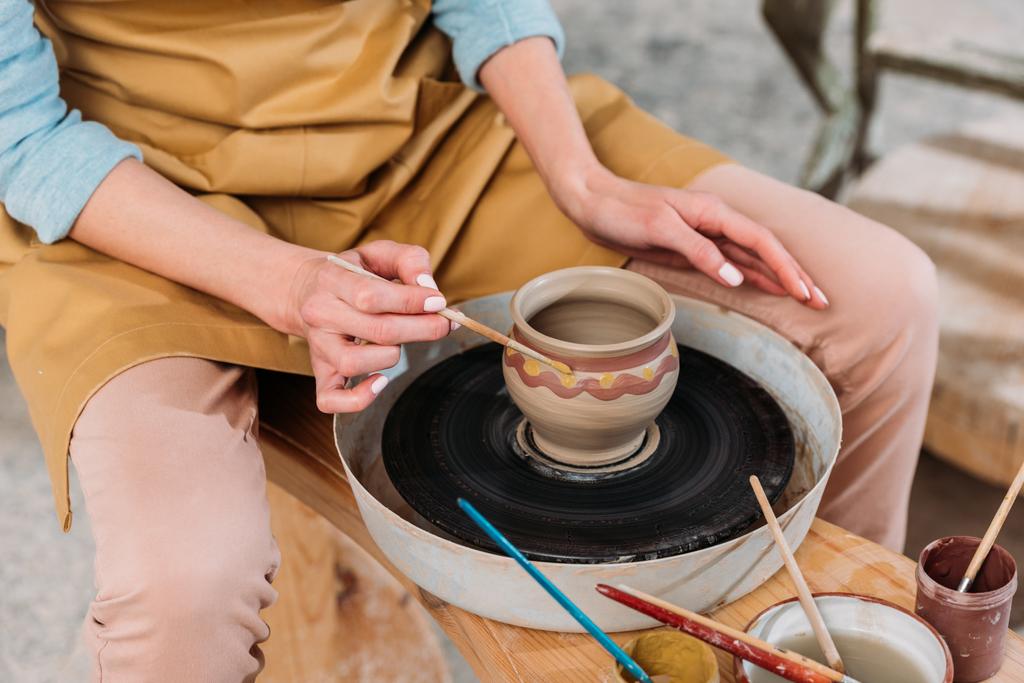 vista recortada de la mujer pintando olla de cerámica tradicional en taller de cerámica
  - Foto, Imagen