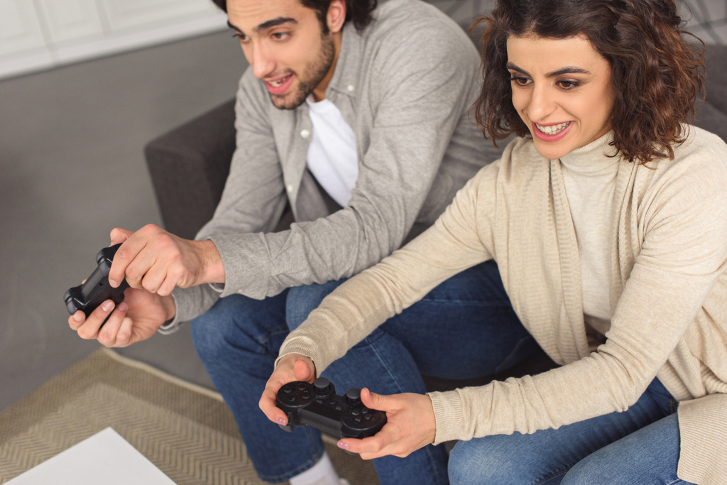 Joyeux jeune couple jouer à un jeu vidéo à la maison
 - Photo, image