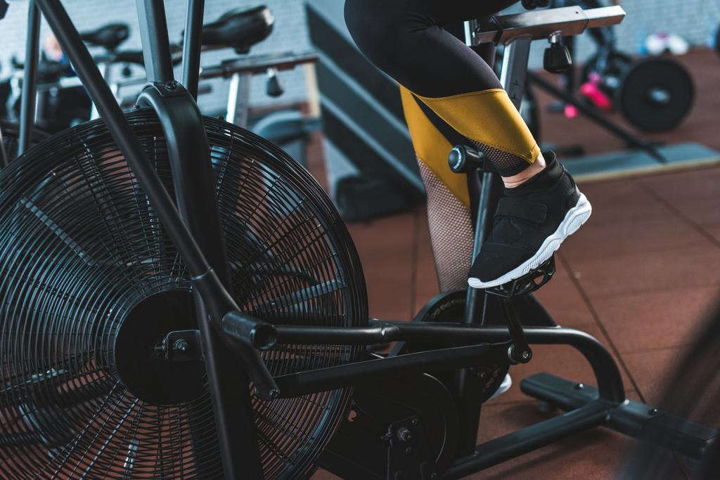 Imagem cortada de esportista fazendo treino em bicicleta de exercício no centro esportivo
 - Foto, Imagem