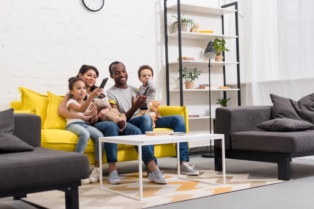 happy young family watching tv together at living room - Photo, Image