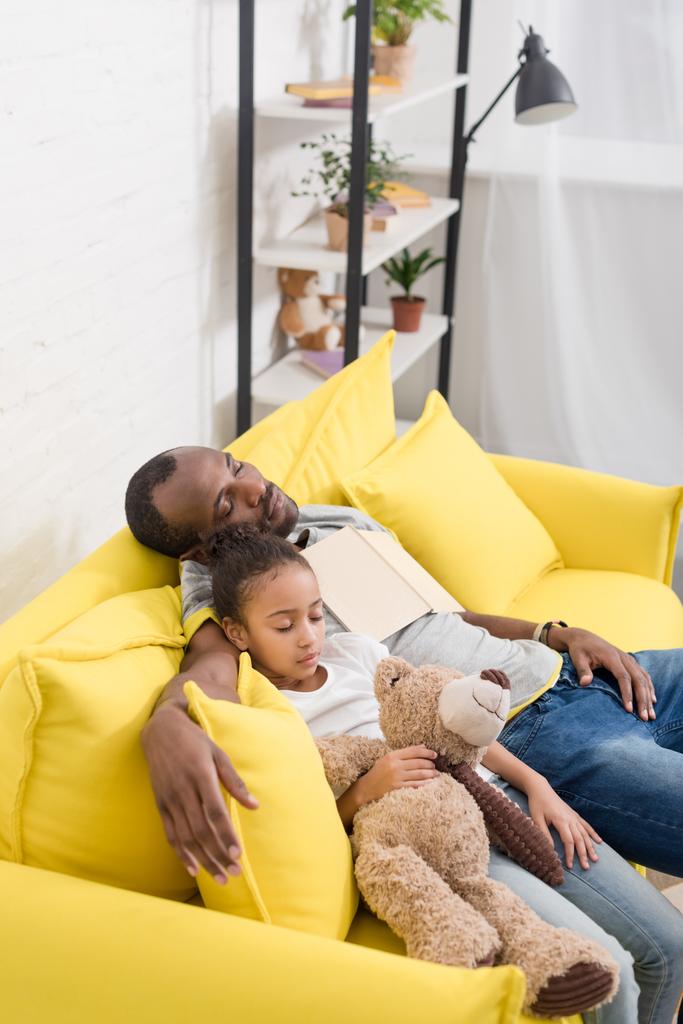 батько і красива дочка сплять разом на дивані після читання казки
 - Фото, зображення
