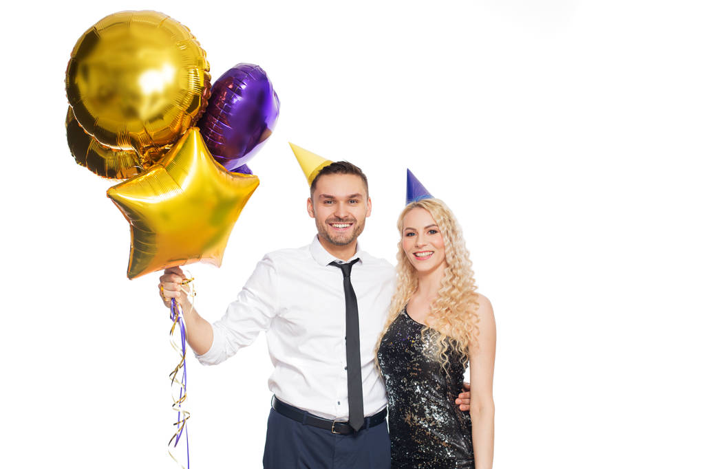 ευτυχισμένο ζευγάρι με κόμμα καπάκια και μπαλόνια - Φωτογραφία, εικόνα