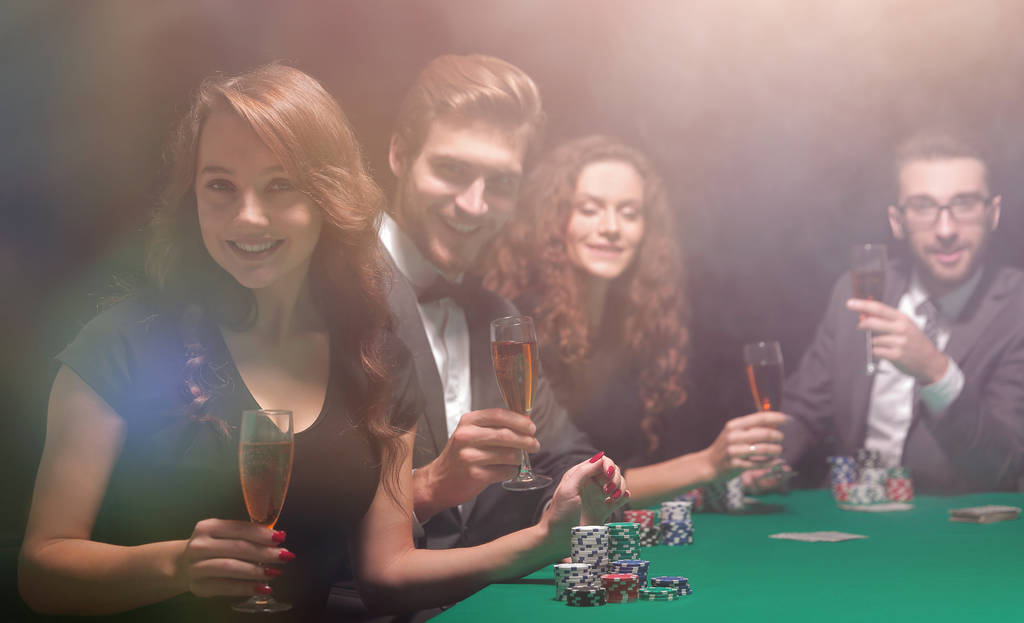 jugadores de póquer con una copa de vino, sentado a la mesa
 - Foto, Imagen