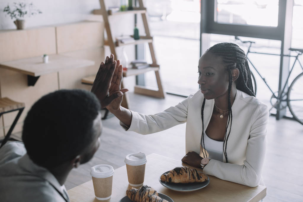 des amis afro-américains se donnent à fond à table dans un café
 - Photo, image